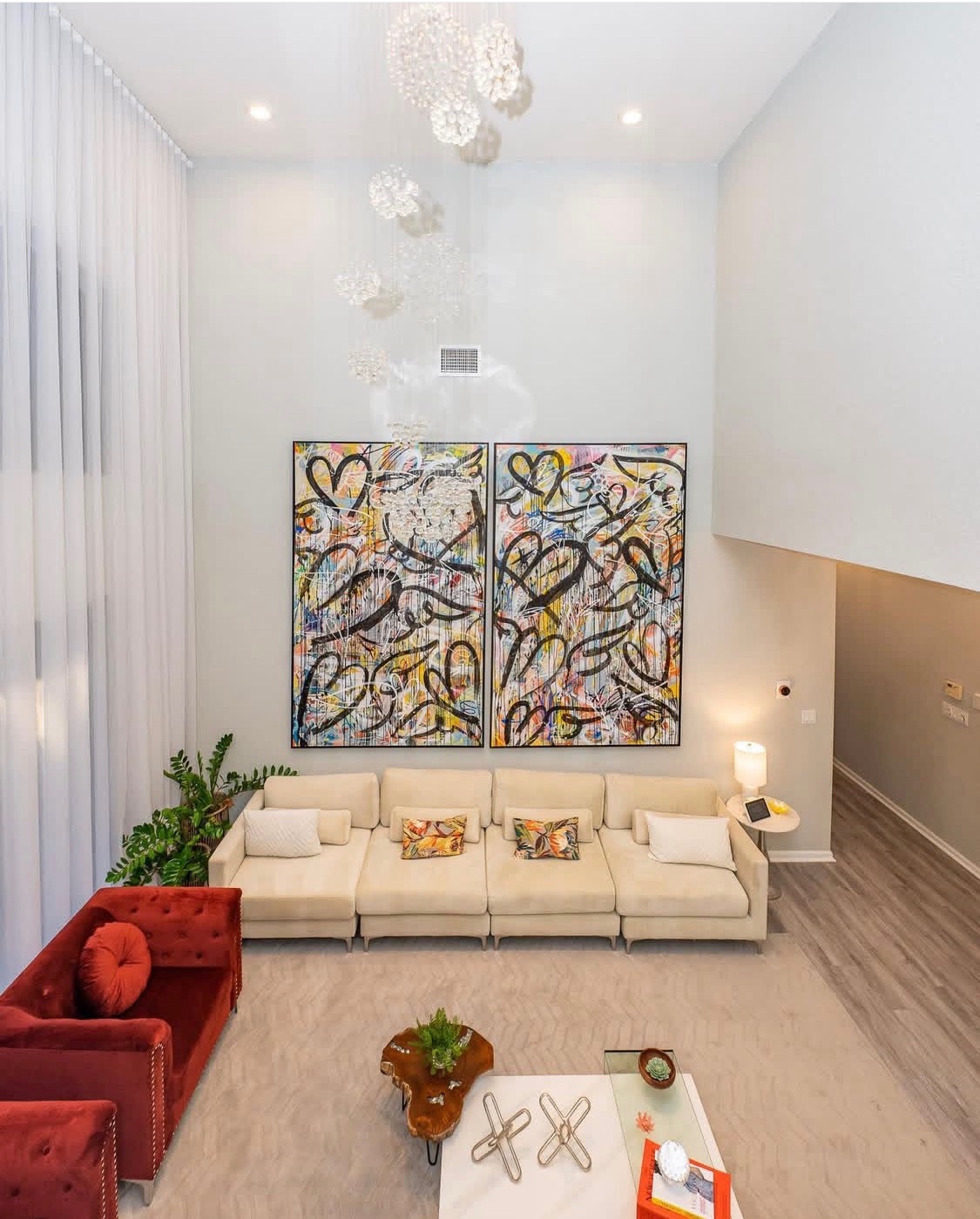 Double-height living room with tall sheer drapery and custom finish carpentry