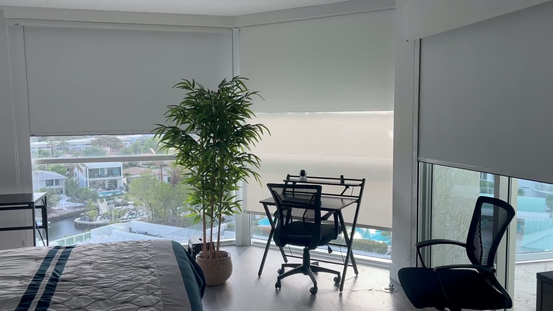 Motorized roller shade lowering over a marina view