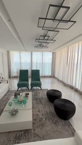 Sheer curtains running the full length of an oceanfront living and dining room